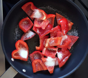 Zucker kommt in die Marinade für die Paprika